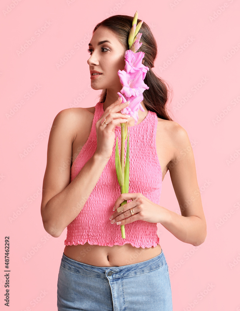 Fashionable woman with Gladiolus flower on color background