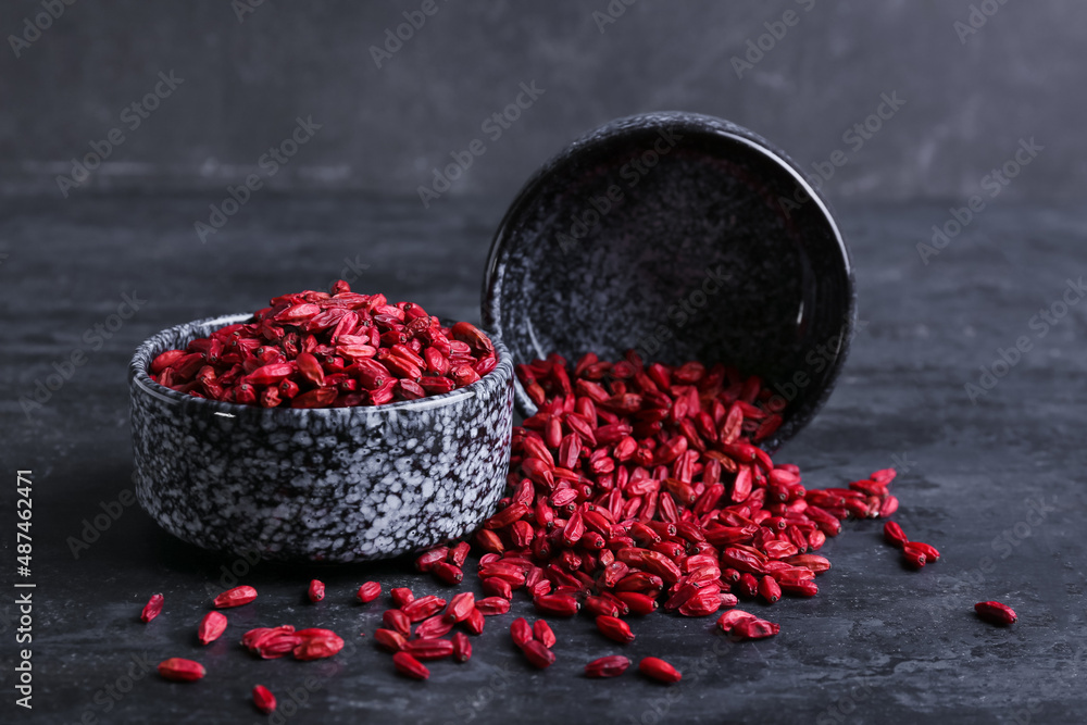 Bowl with dried barberries on dark background