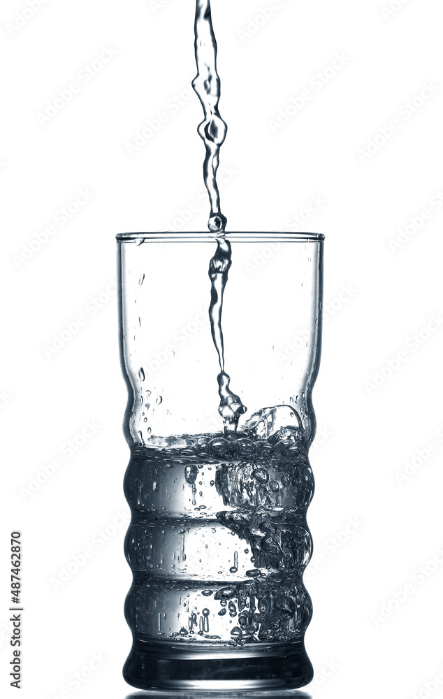 Pouring of clear water in glass isolated on white