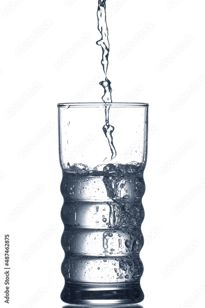 Pouring of clear water in glass isolated on white