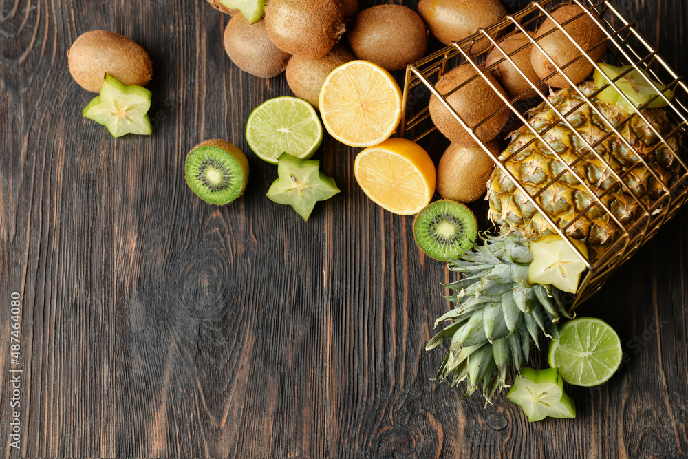 Basket with fresh juicy fruits on wooden background