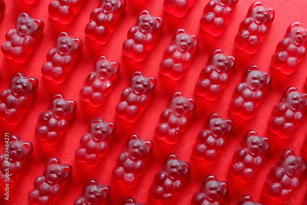 Sweet jelly bears on red background, closeup