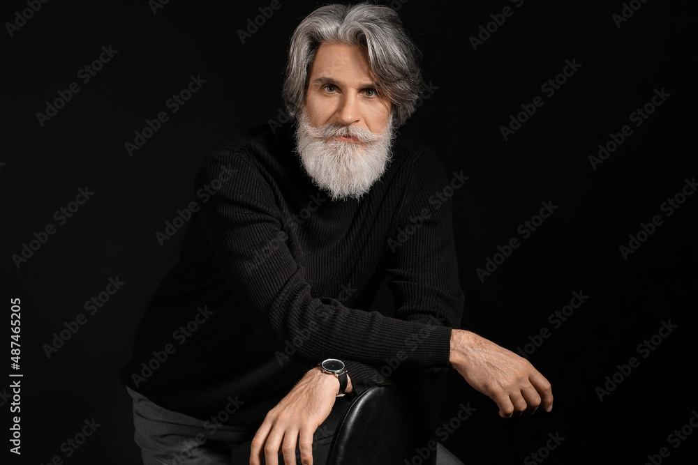 Portrait of handsome mature bearded man on dark background