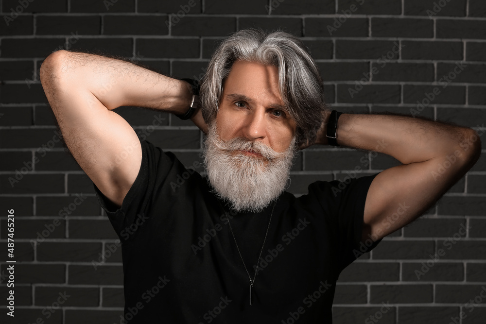 Portrait of handsome mature bearded man on dark background