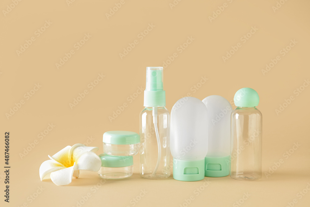 Set of empty travel bottles and jars on color background