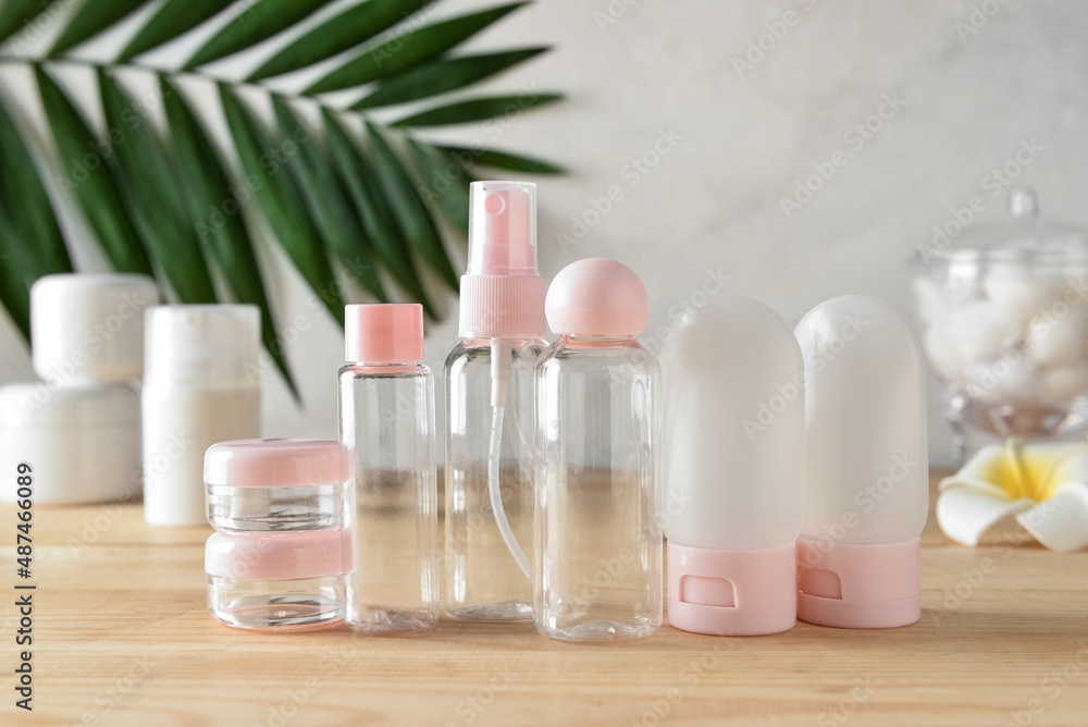 Set of empty travel bottles on wooden table