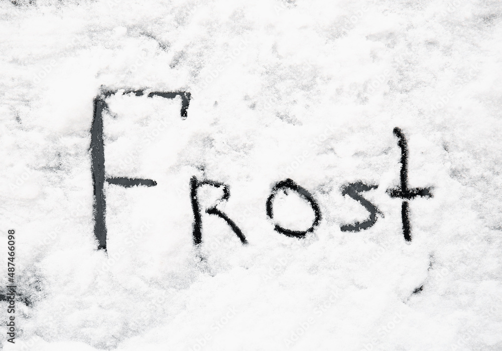 Word FROST written on car covered with snow