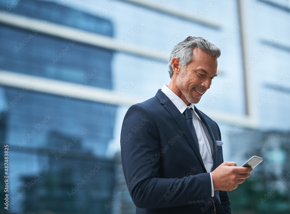 Out of the office but they still contacting me. Shot of a handsome mature businessman in corporate a