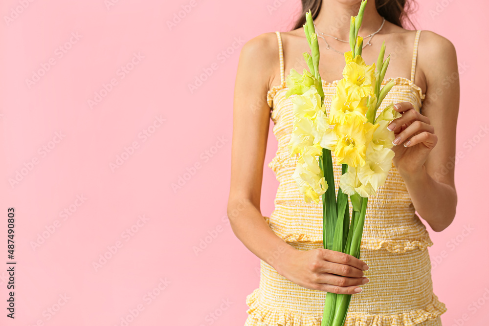 Young woman holding beautiful bouquet of Gladiolus flowers on color background