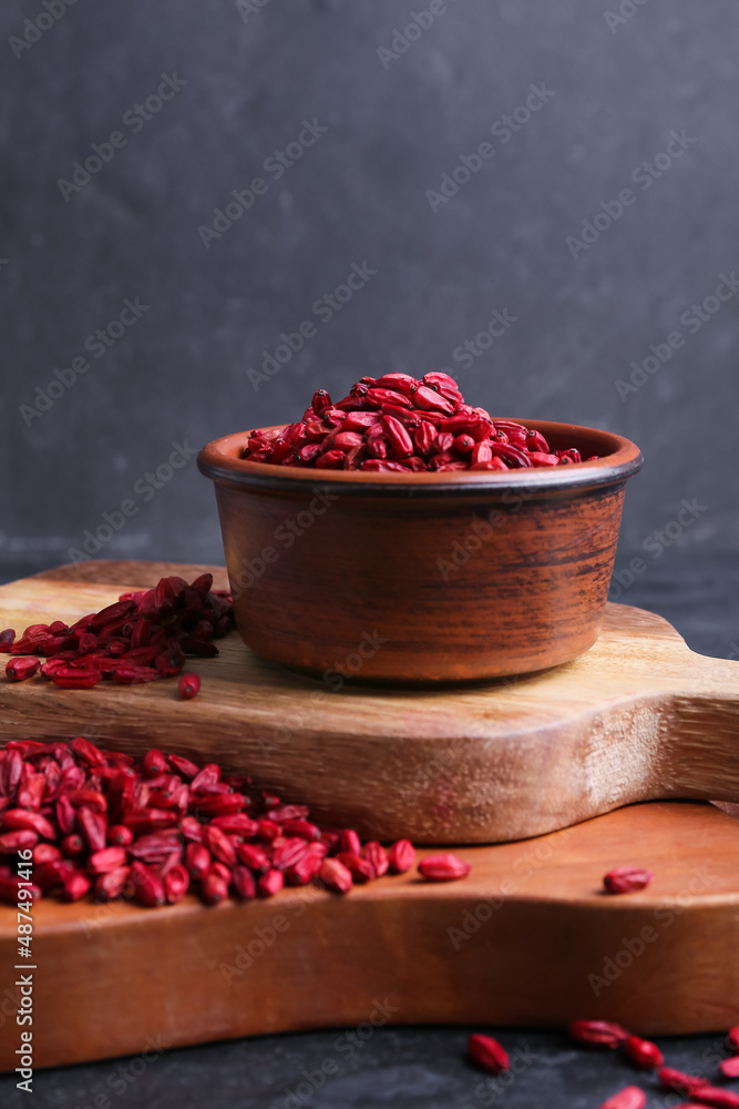 Bowl with dried barberries on dark background