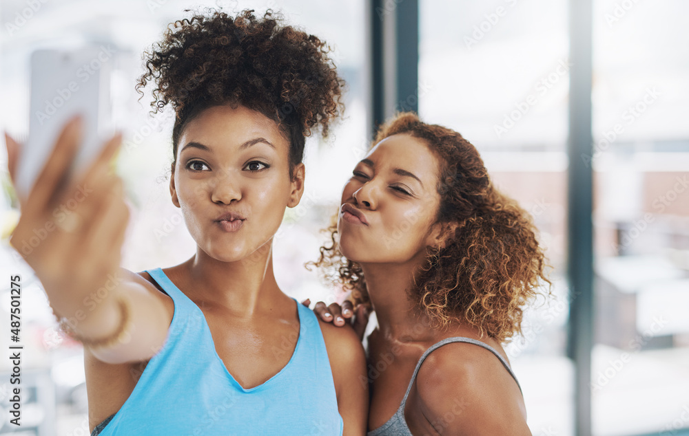 And one for our followers. Cropped shot of two young women taking a selfie after yoga class.