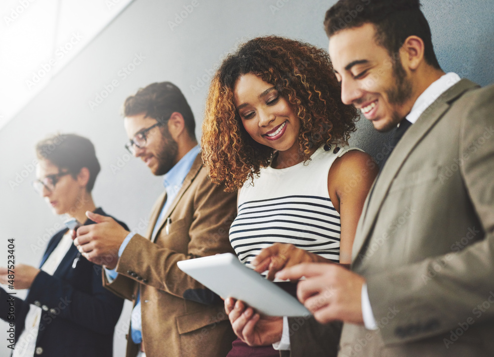 Digitally engaging their customers. Shot of a group of businesspeople using wireless technology toge