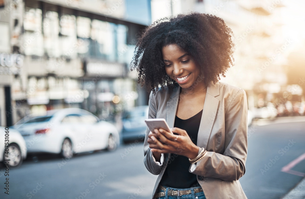 I love it when I receive texts with good news. Shot of a young businesswoman using a cellphone in th