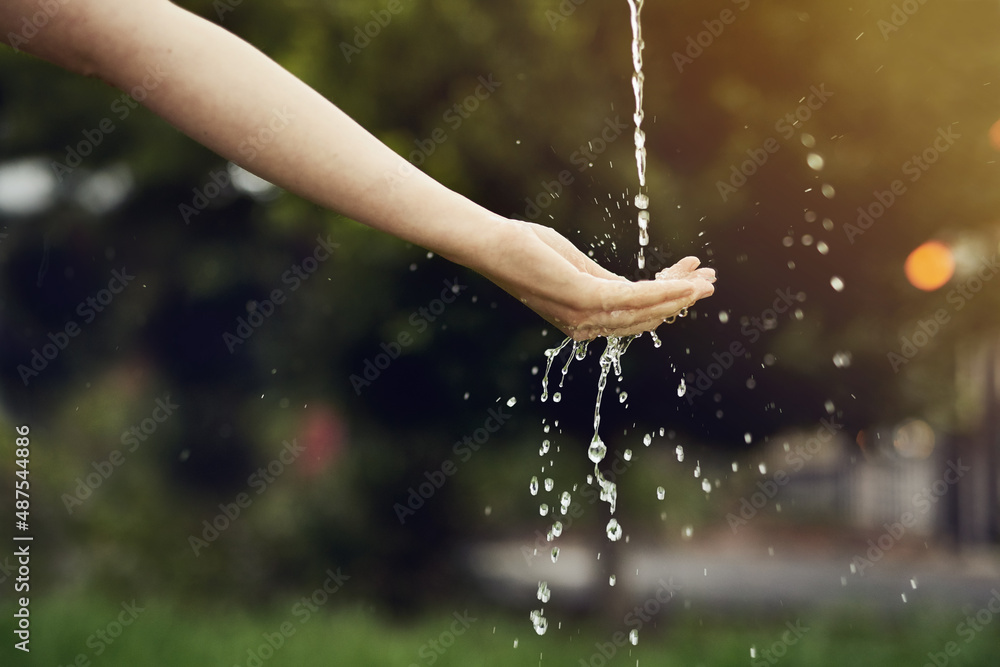 Make every drop count. Cropped shot of water running on a womans hand outside.