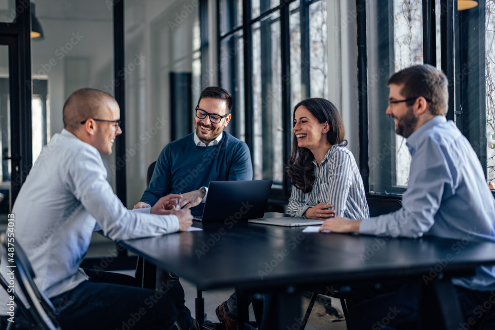 Laughing caucasian programmers, discussing the feature in their software, on a meeting.