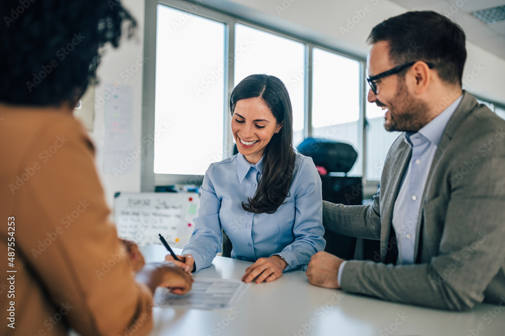 Brunette businesswoman signed a contract together with her husband.