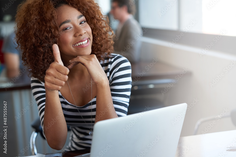 Youve got her seal of approval. Portrait of a young woman winking and giving the thumbs up while sit