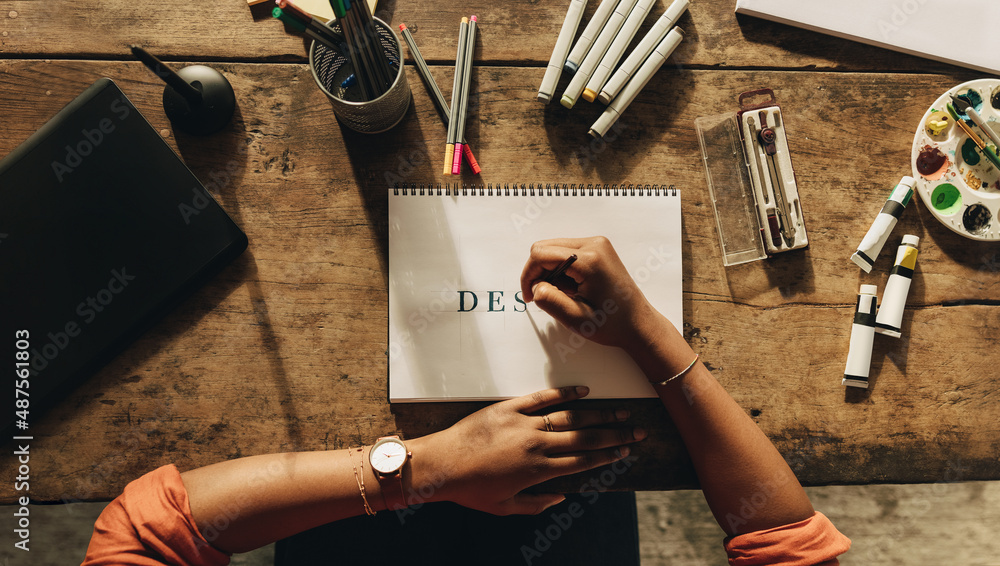 Designer drawing on a note pad at her desk