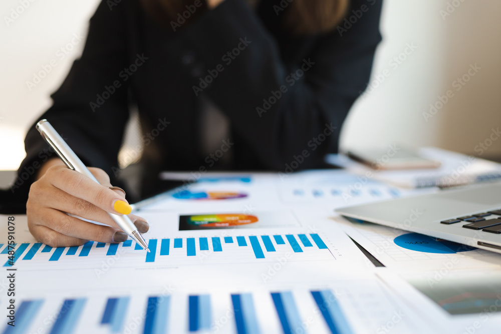 Close-up business woman analyzing business report and planning.