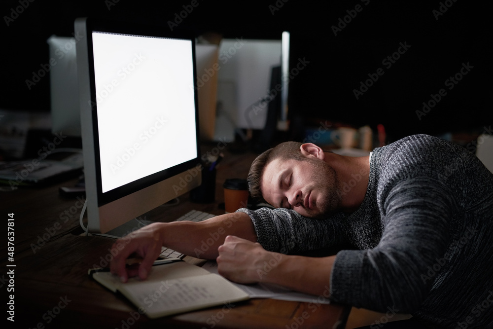 Ill just rest my eyes for a moment. Shot of a tired computer programmer sleeping at his desk.