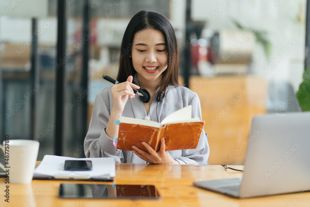 亚洲年轻女子在日记中记笔记。女大学生准备考试笔记