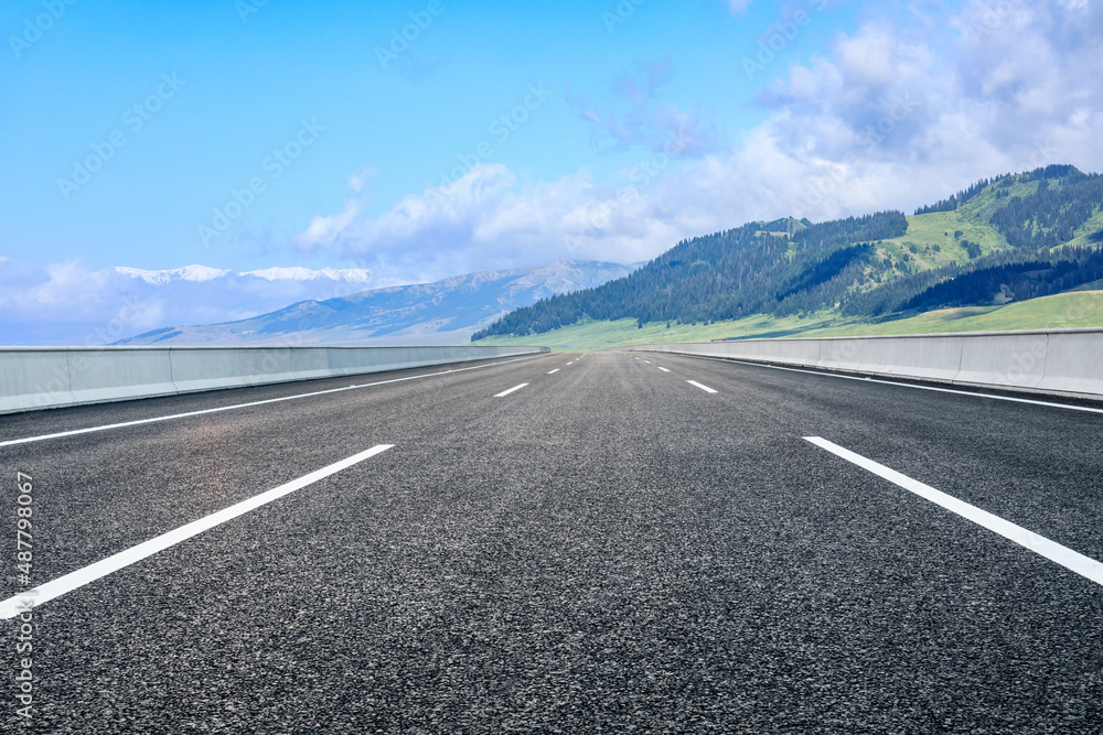 Asphalt road and mountain nature landscape under blue sky