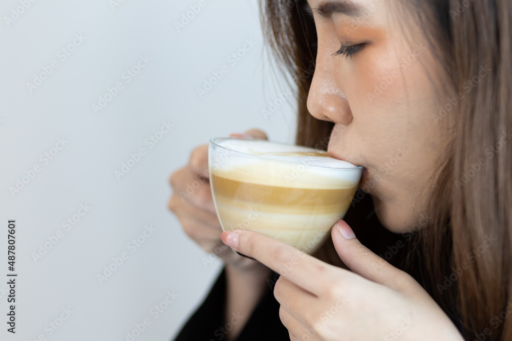 Close-up woman smiling and happy while drinking coffee.