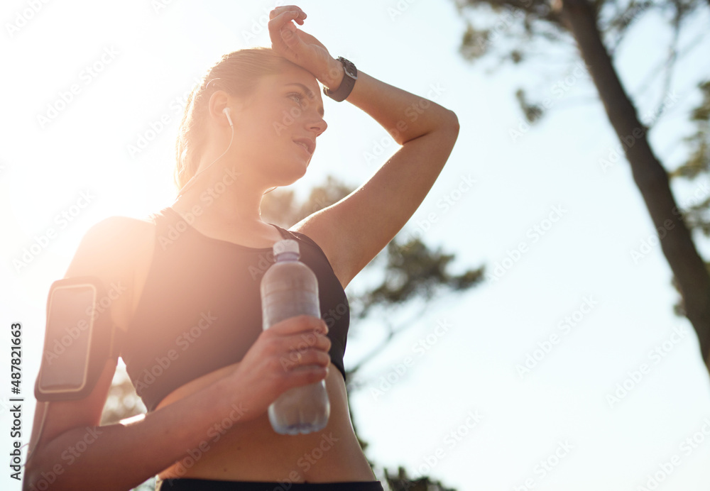 知道你要去哪里，然后到达那里。一个健康的年轻女人在拍摄期间停下来喝水的镜头