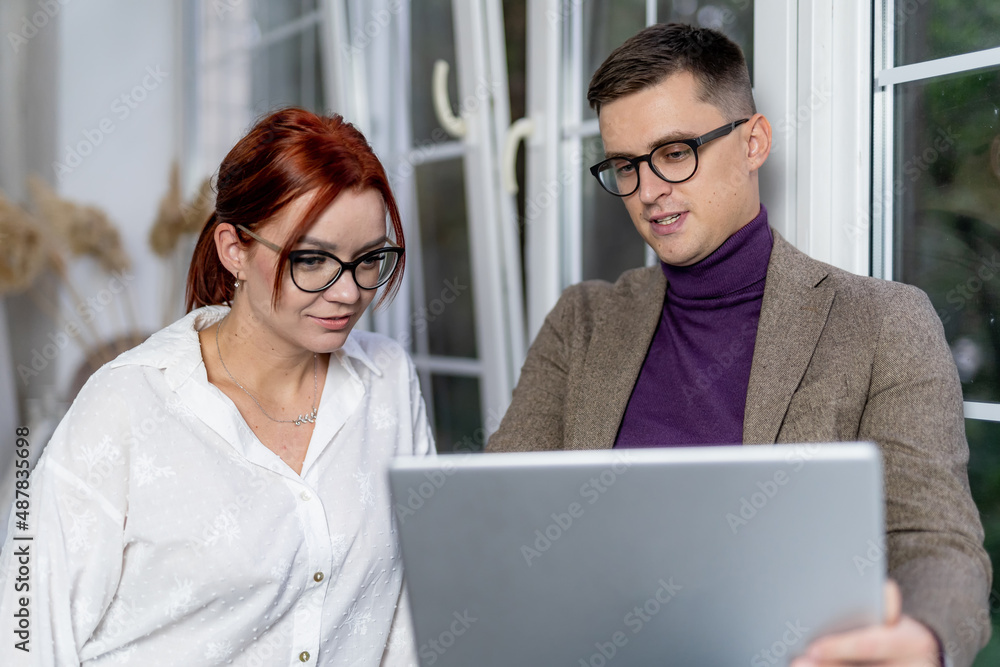 Cheerful business team working on computer in office. Man and woman colleagues. Business concept.