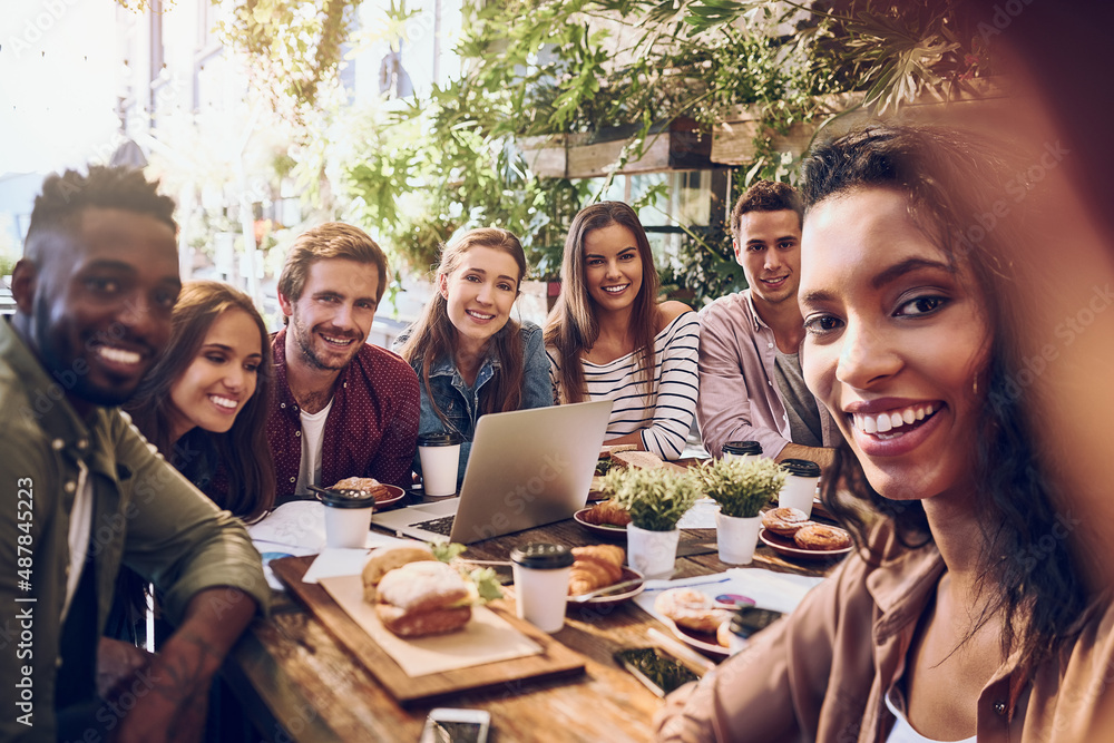 Always up for a work selfie. Shot of a woman taking a selfie with her colleagues while out for lunch