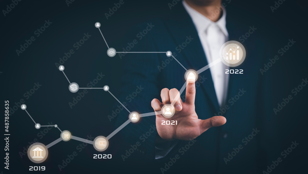 Businessman touch line arrow with number 2022 on the graph chart of stock market ,Technology Process