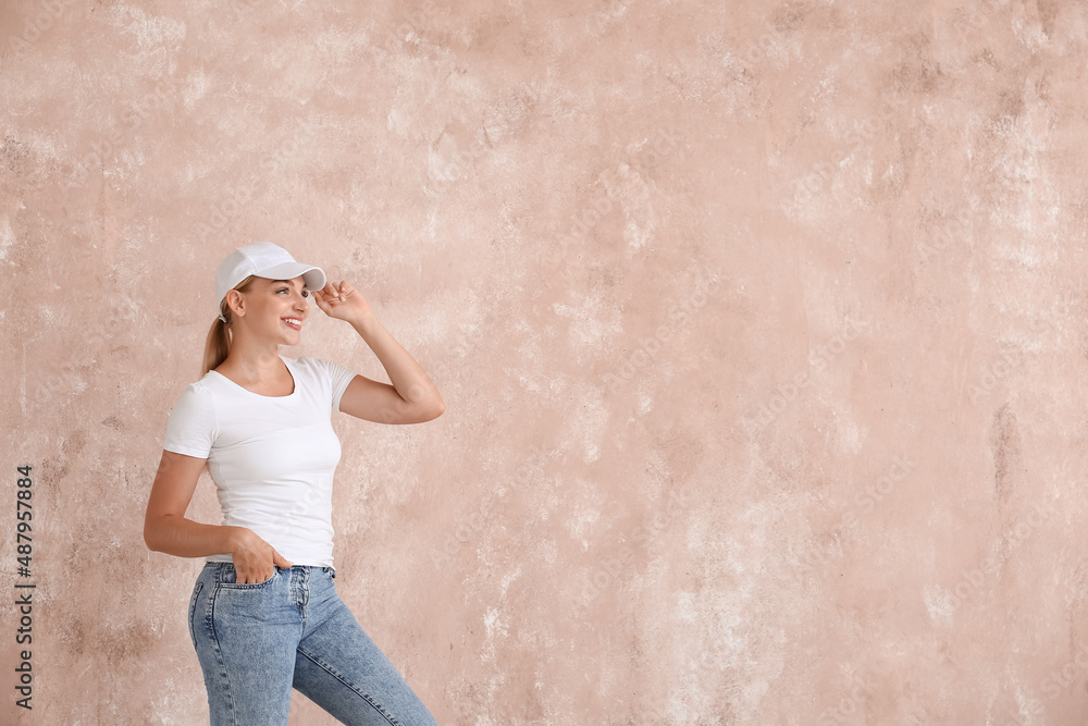 Fashionable young woman in stylish jeans near color wall