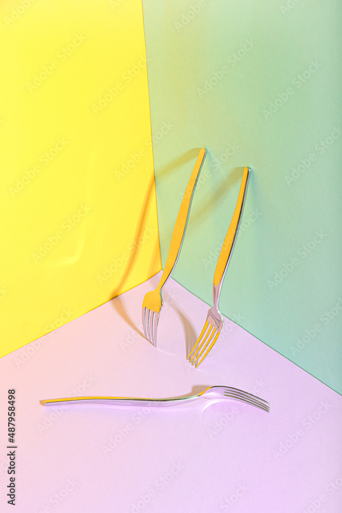 Stainless steel forks on colorful background