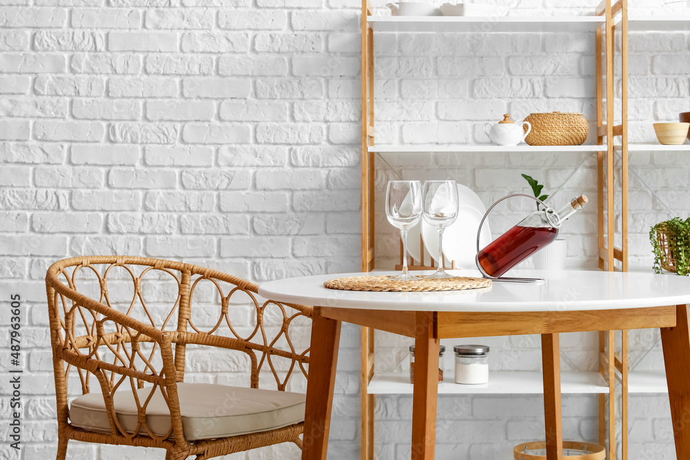 Interior of modern kitchen with table, armchair and shelves