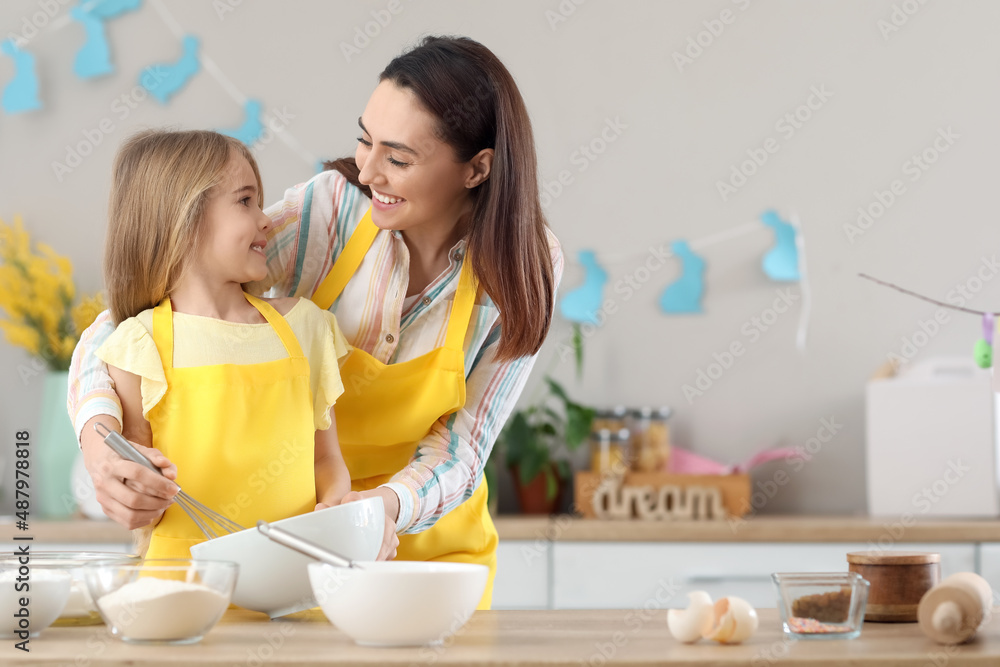 Little girl with her mother preparing dough for Easter cake in kitchen