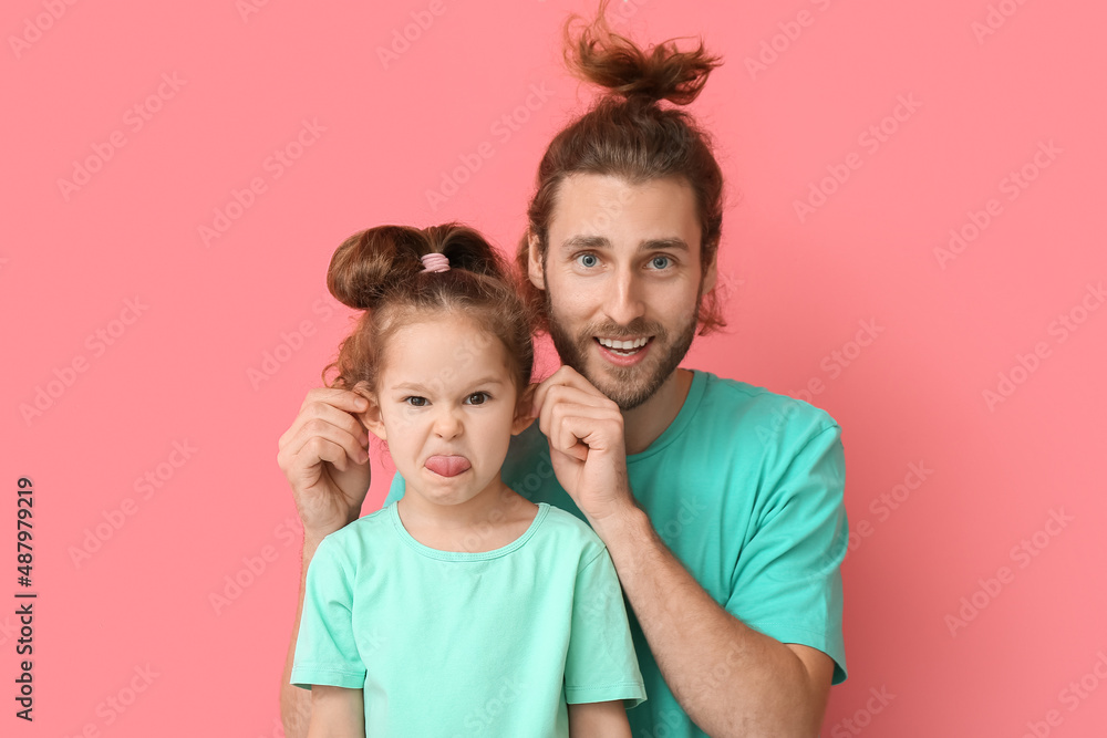 粉色背景下的滑稽男子和她的小女儿。愚人节庆祝活动