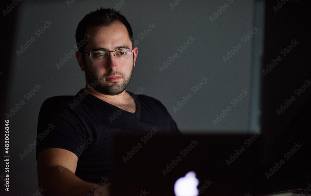 Hes got deadlines to meet. Cropped shot of a young man working late in his office.