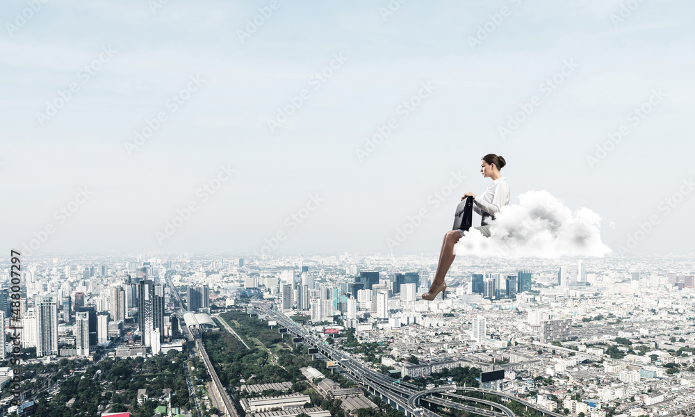 Businesswoman or accountant on cloud floating high above modern city