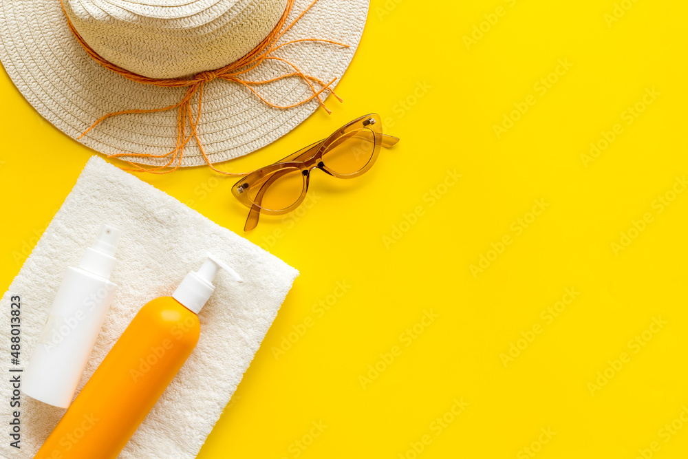 Summertime concept with straw hat and bottles od sunscreen