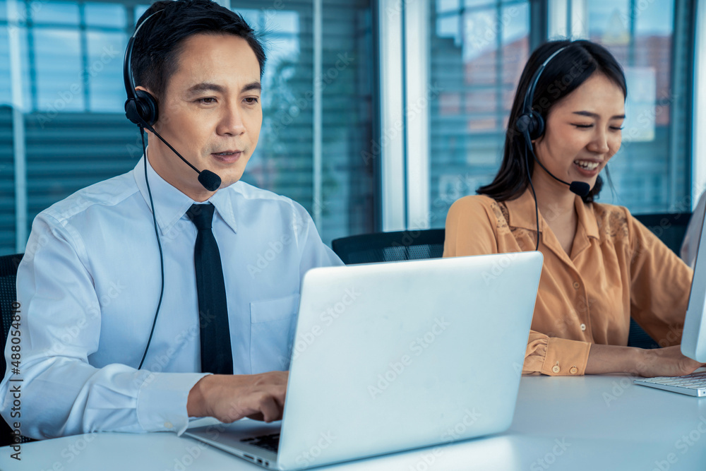 Business people wearing headset working actively in office . Call center, telemarketing, customer su