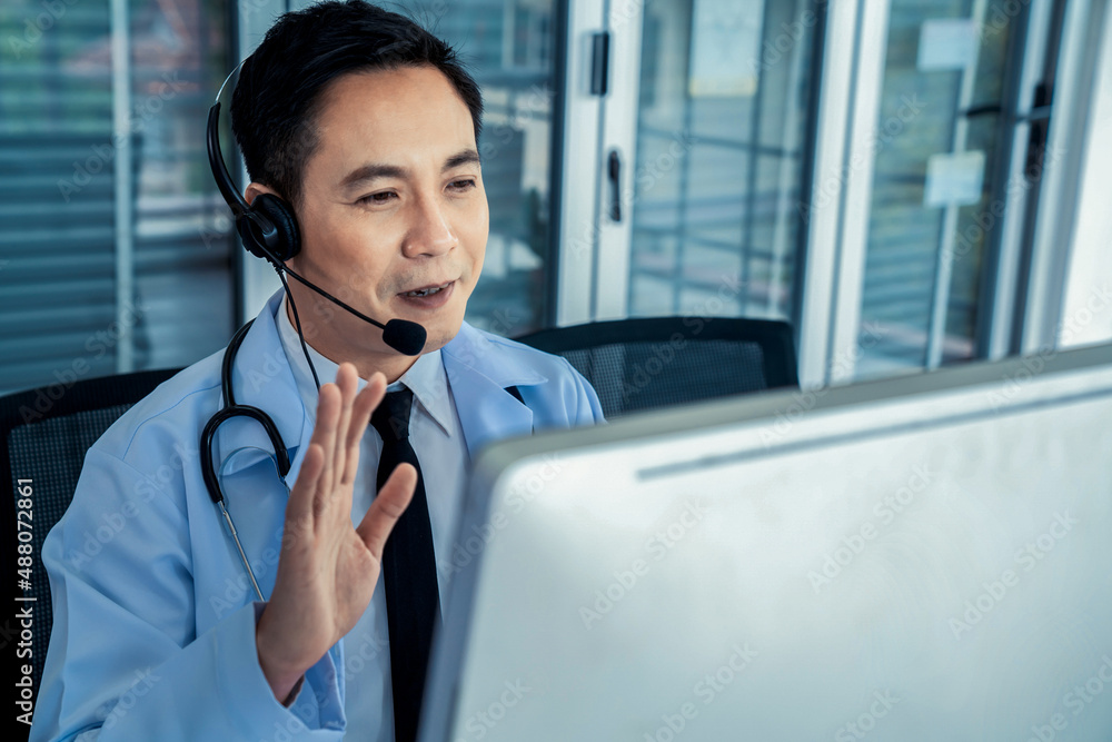 Doctor wearing headset talking actively on video call in a clinic or hospital . Concept of telehealt