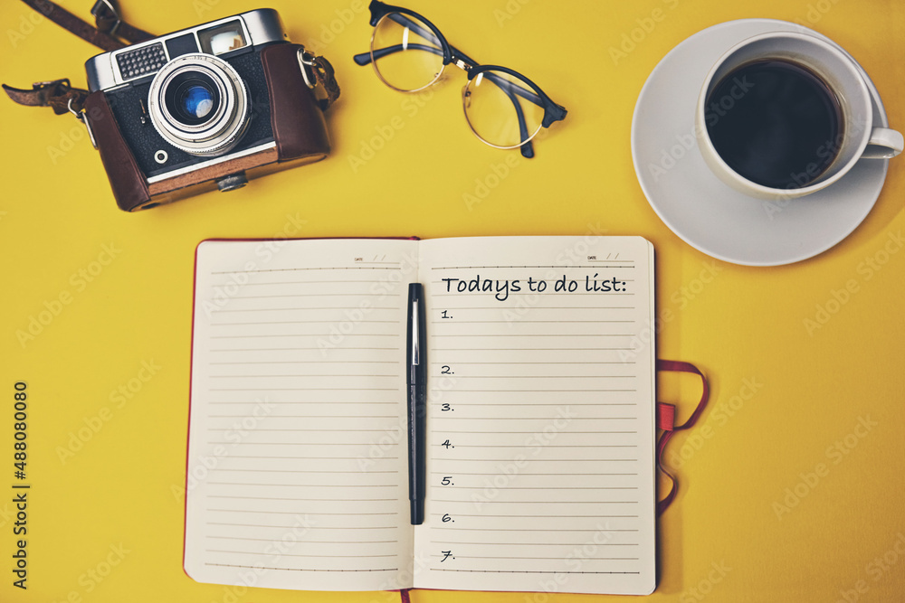 Stay organized, stay productive. High angle shot of a notebook with a to do list on a yellow desk.