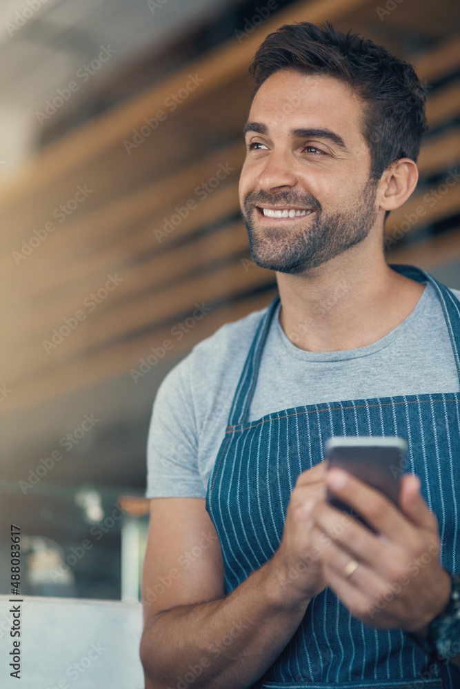 利用咖啡店管理应用程序。一名年轻人在工作时使用手机的照片