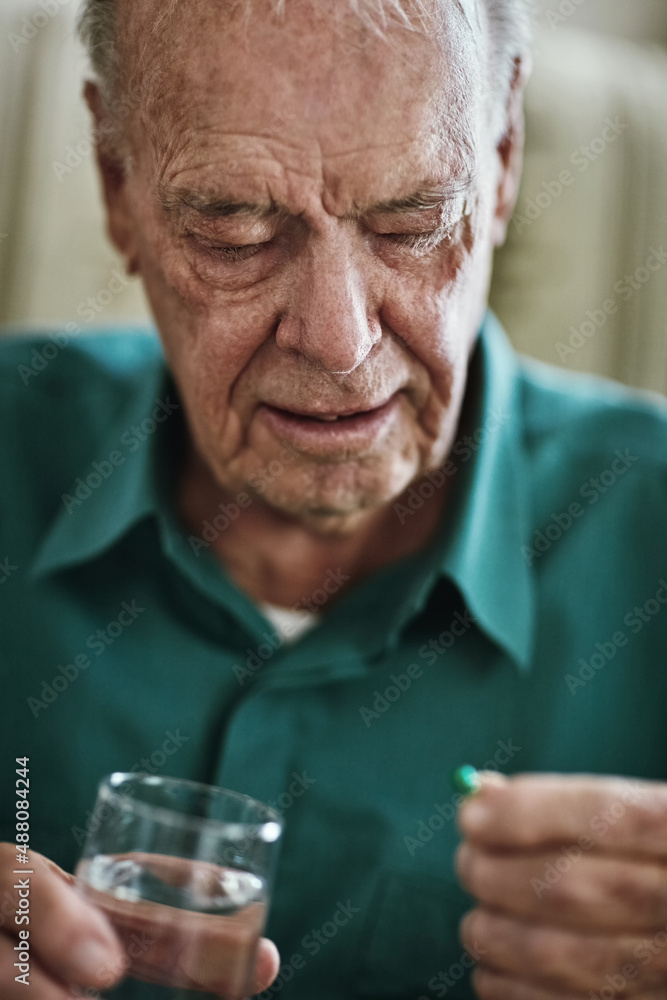 Managing his chronic condition to stay healthy. Cropped shot of a senior man about to take his medic