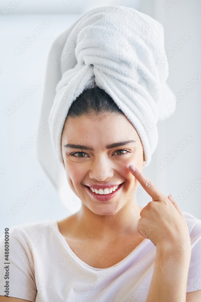 Give your skin the moisture it needs. Portrait of a beautiful young woman applying moisturizer to he