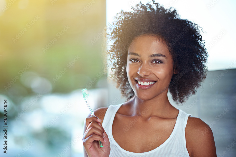 Working for that winning smile. Cropped portrait of a young woman brushing her teeth in the bathroom