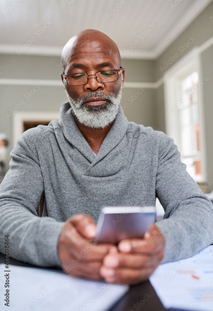 Now you can bank from anywhere. Cropped shot of a senior man using his cellphone while working on hi