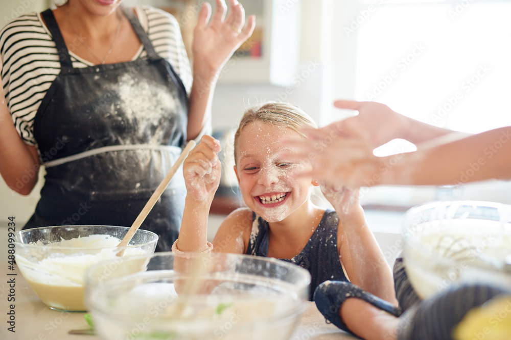 脏乱但美味。两个小女孩和妈妈在厨房里烤面包时玩得很开心的镜头