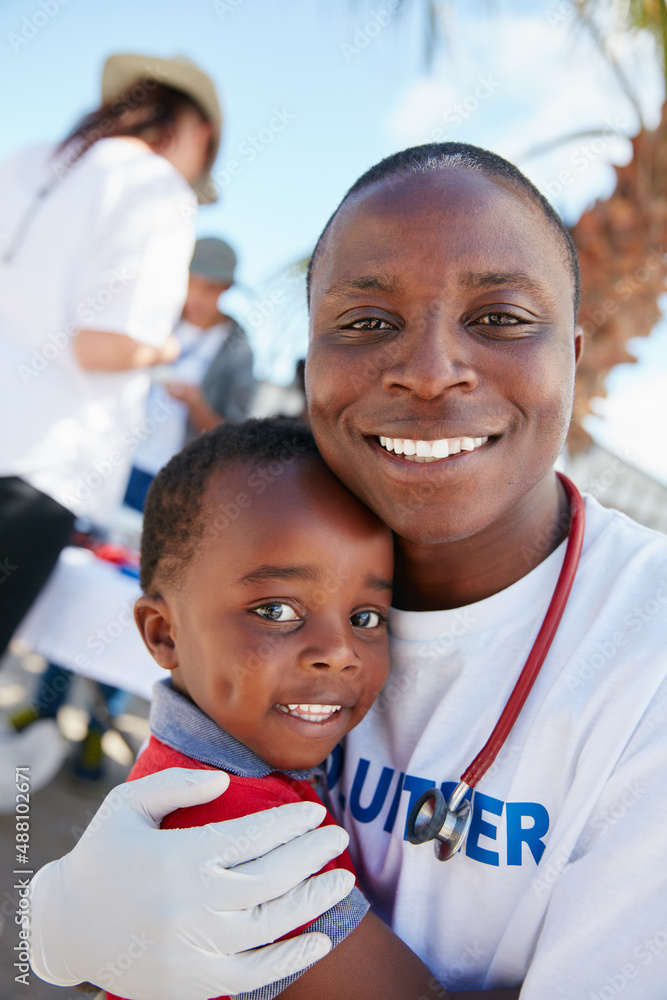 Volunteering for the love of kids. Portrait of a caring volunteer doctor giving checkups to underpri