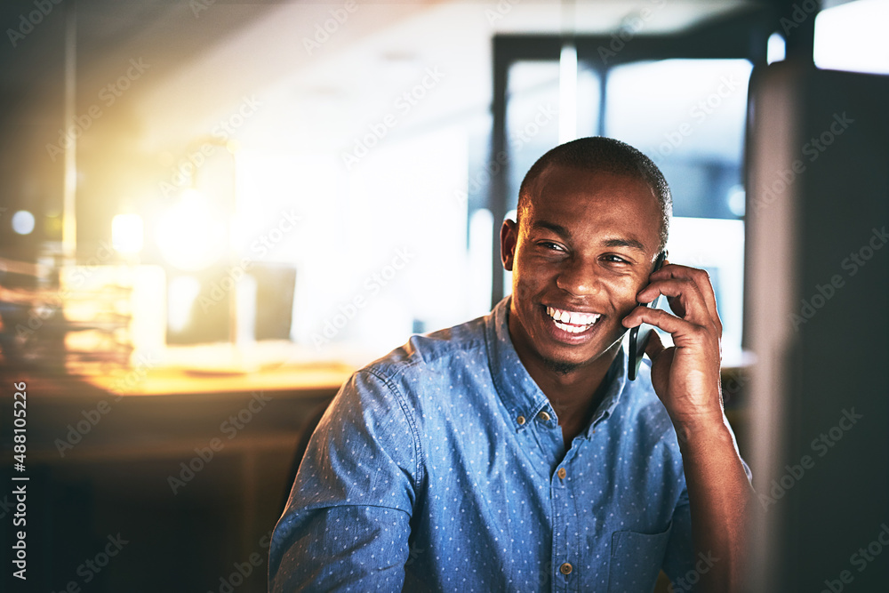 Hows work going Great. Shot of a young businessman using a mobile phone during a late night in a mod